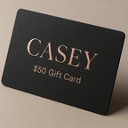 Black gift card with 'CASEY' and '$50 Gift Card' text on a beige background